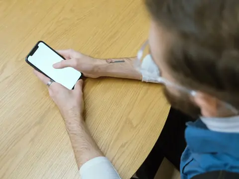 Holding a phone over a wooden table