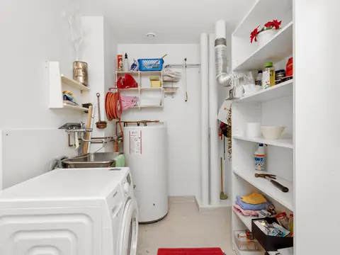 A home laundry room with a washer and a tall water heater
