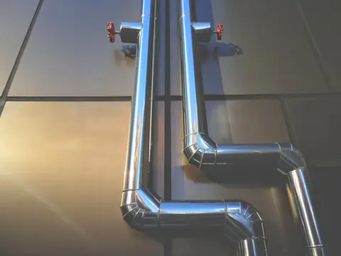 Steel water pipes with shut-off valves on a wall