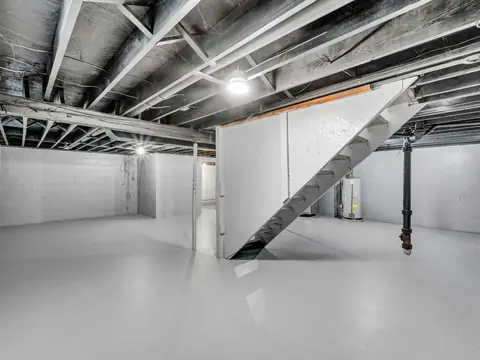 A bright, clean basement with open ceiling joists