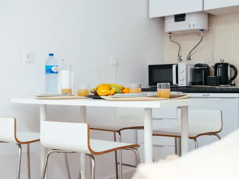 A kitchen with a small water heater on the wall