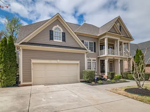 A two-story suburban house with a garage on a sunny street
