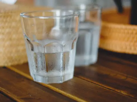 A glass of tap water on a wooden table