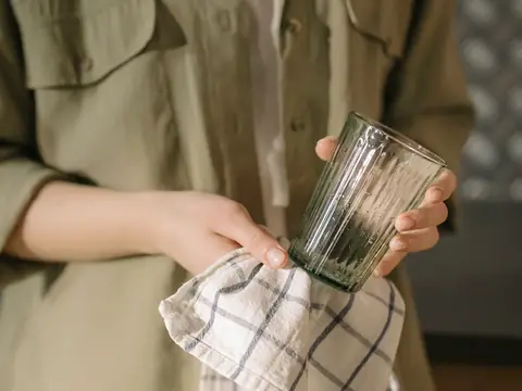 Drying a glass with a checked cloth